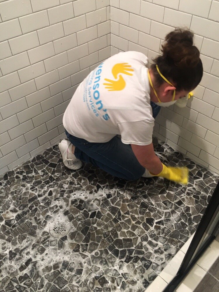 A girl cleaning floors of a bathroom